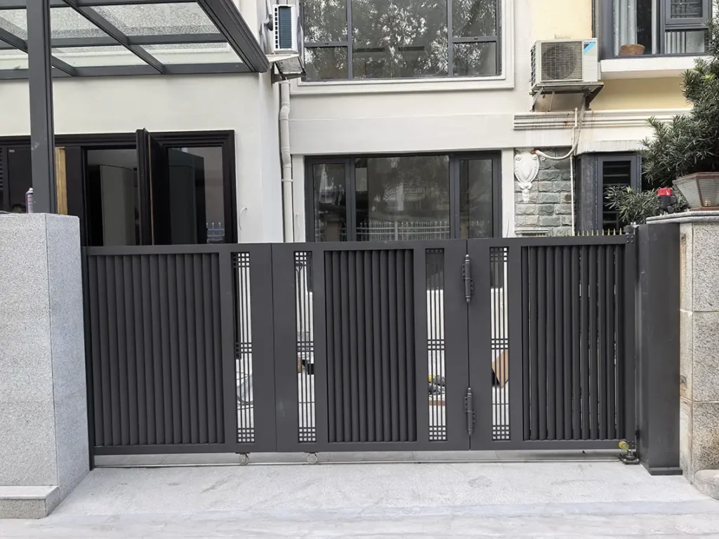 Aluminum track-mounted three-panel folding garden gate for residential courtyard entrance, featuring a modern vertical slat design.